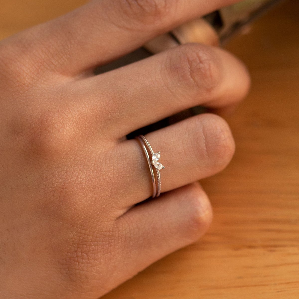 Sterling silver twin pear white zirconia ring shown on a model's finger, close-up detail