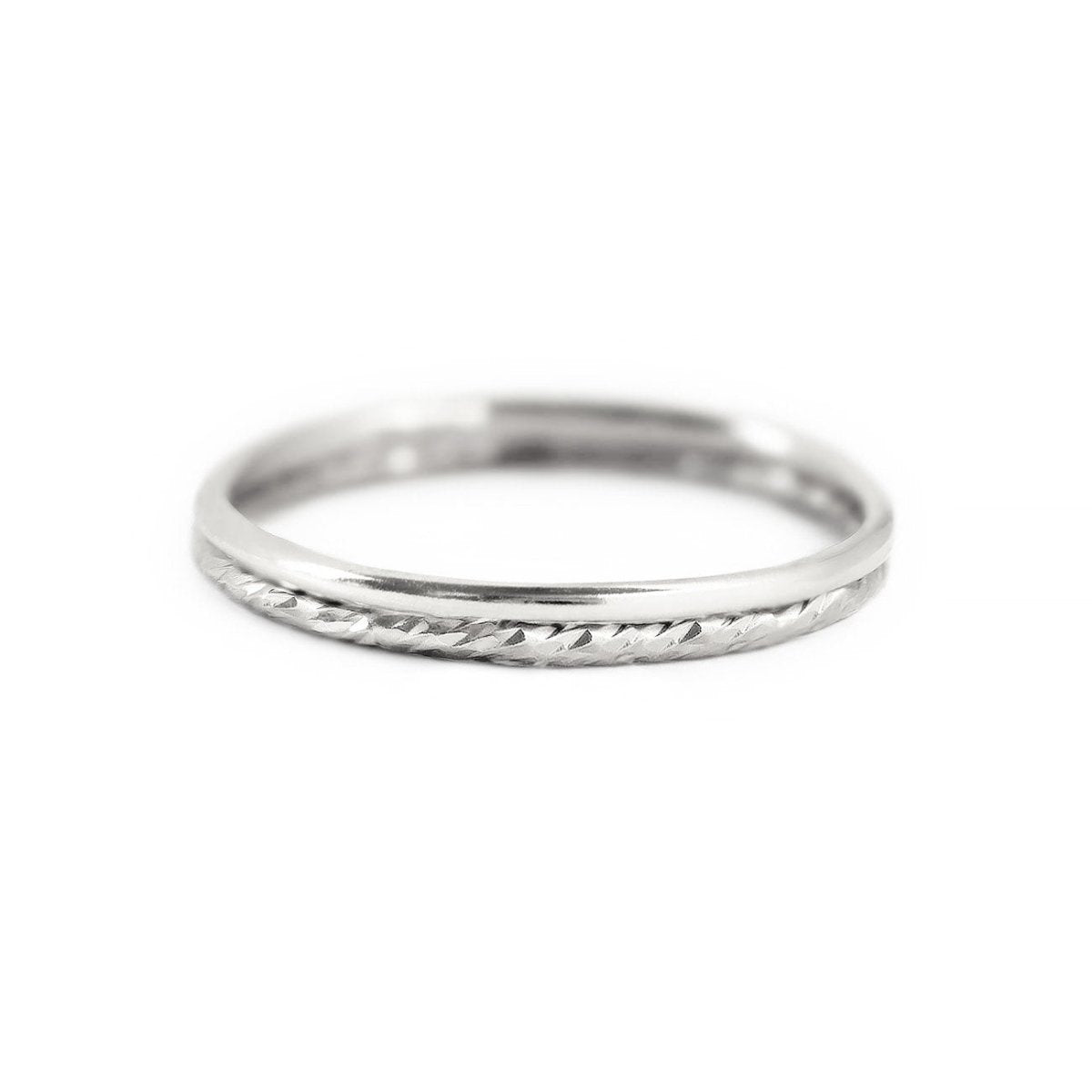 Sterling silver stacking ring set, a plain band and a diamond-cut textured band, on a white background