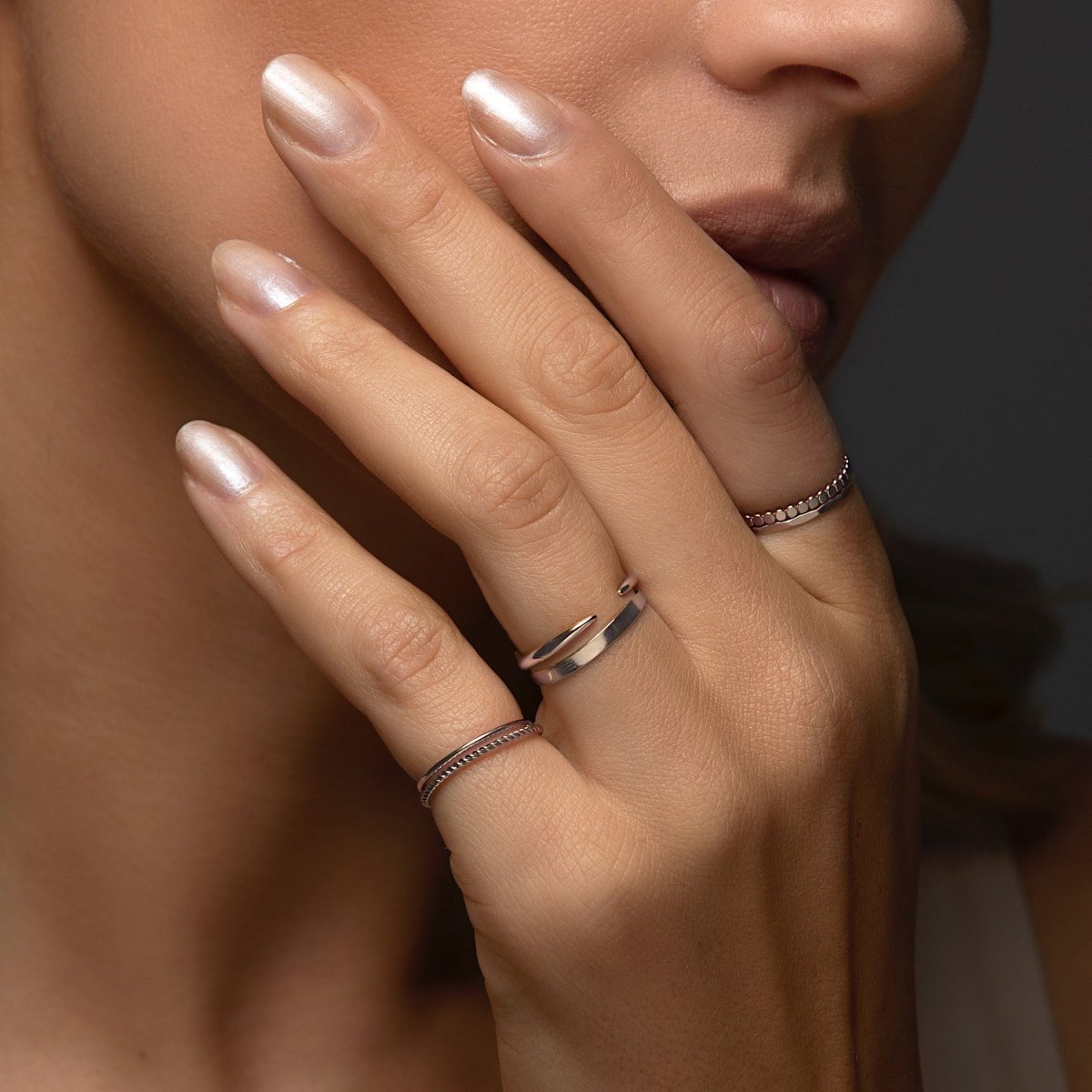 Sterling silver open claw ring stacked on a model's finger, close-up detail