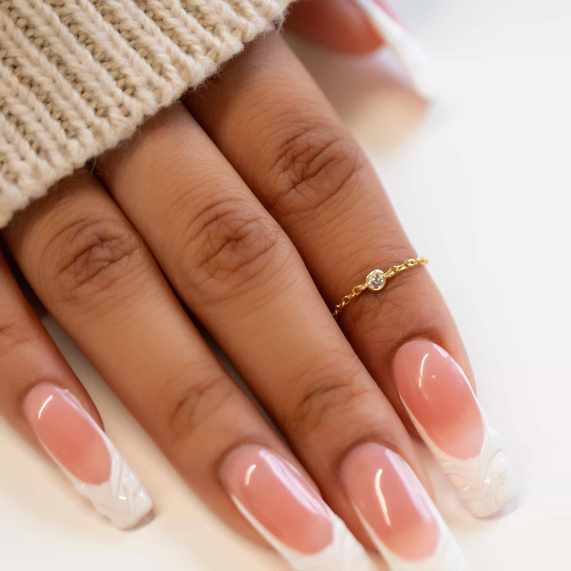 14K gold vermeil delicate chain ring with a bezel-set clear stone, shown on a model's finger