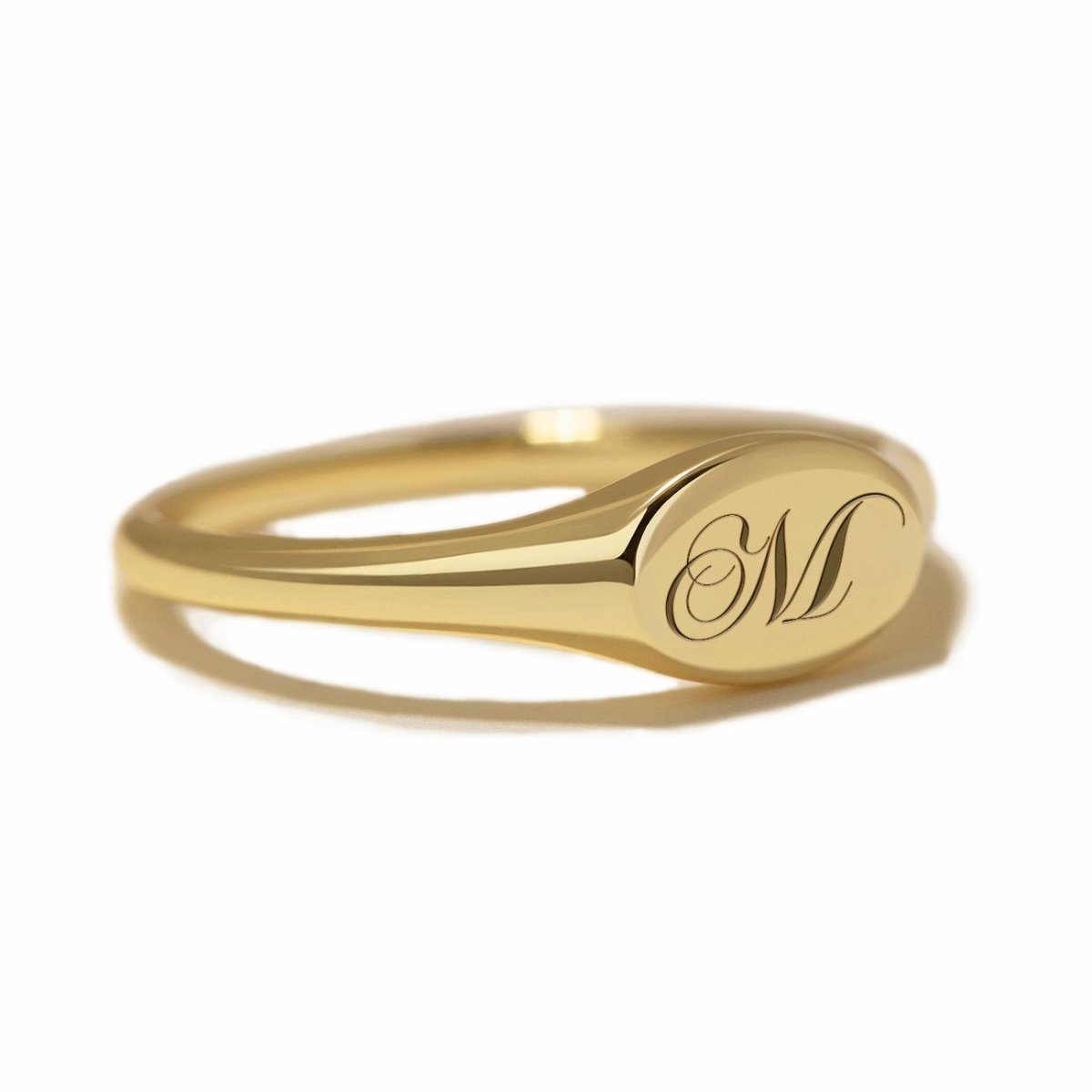 Gold vermeil oval signet ring engraved with an initial, on a white background