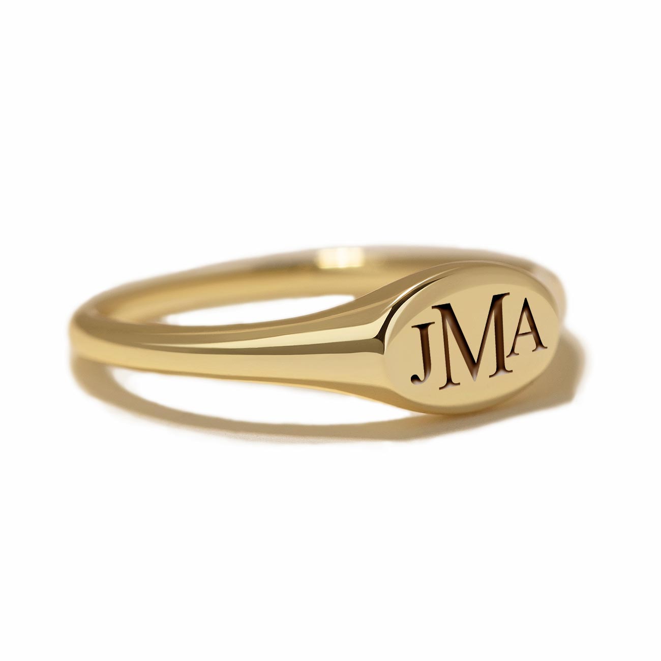 Gold vermeil oval signet ring engraved with a monogram, on a white background