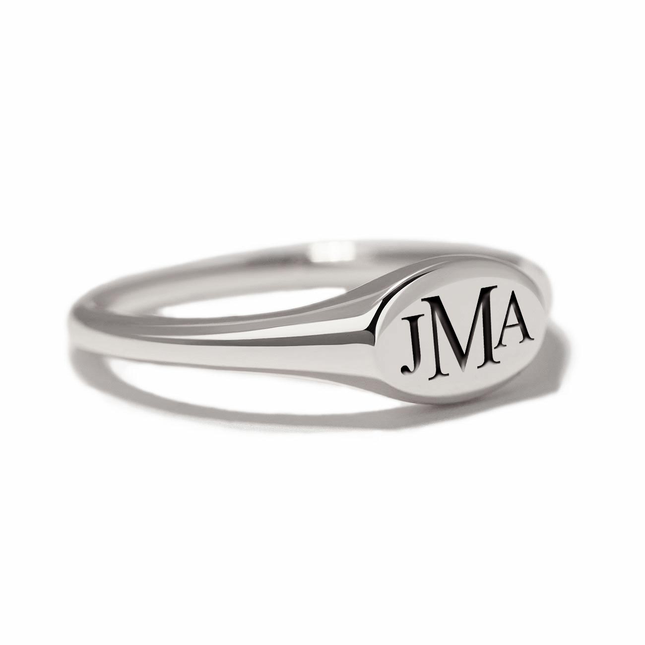 Sterling silver oval signet ring engraved with a monogram, on a white background