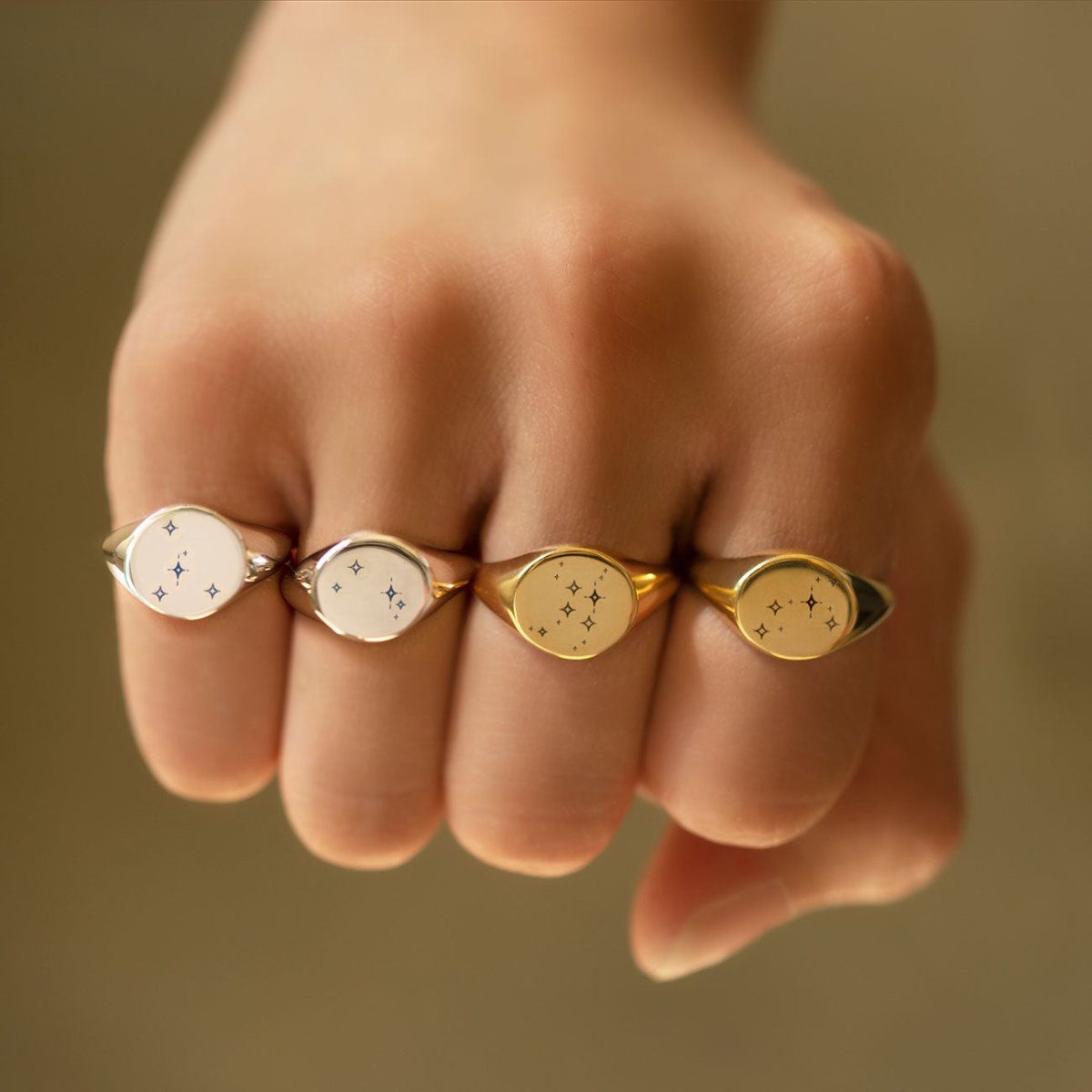 Sterling silver round signet ring engraved with a star constellation, shown on a model's fingers