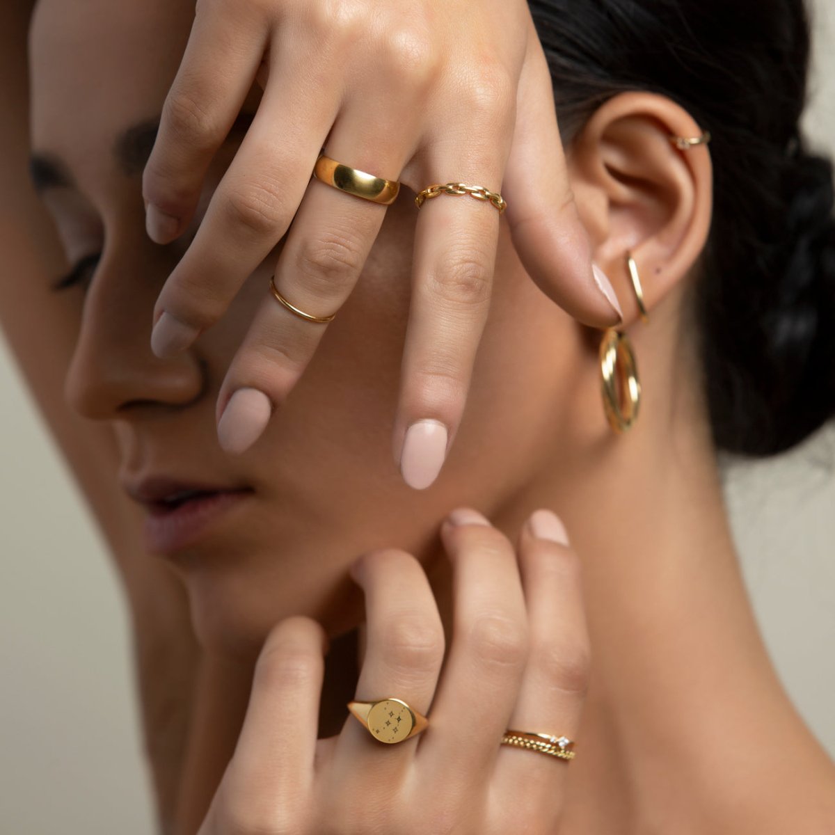 Gold vermeil chain-link ring shown on a model's hand among stacked rings and gold earrings