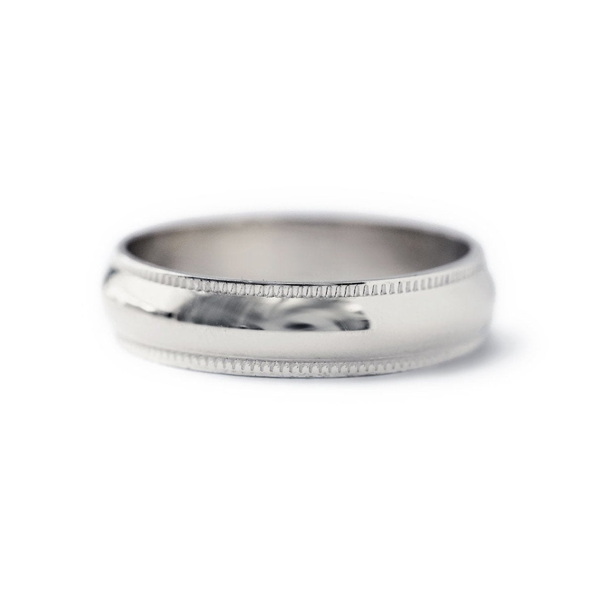 Sterling silver domed band ring with milgrain beaded edges, on a white background