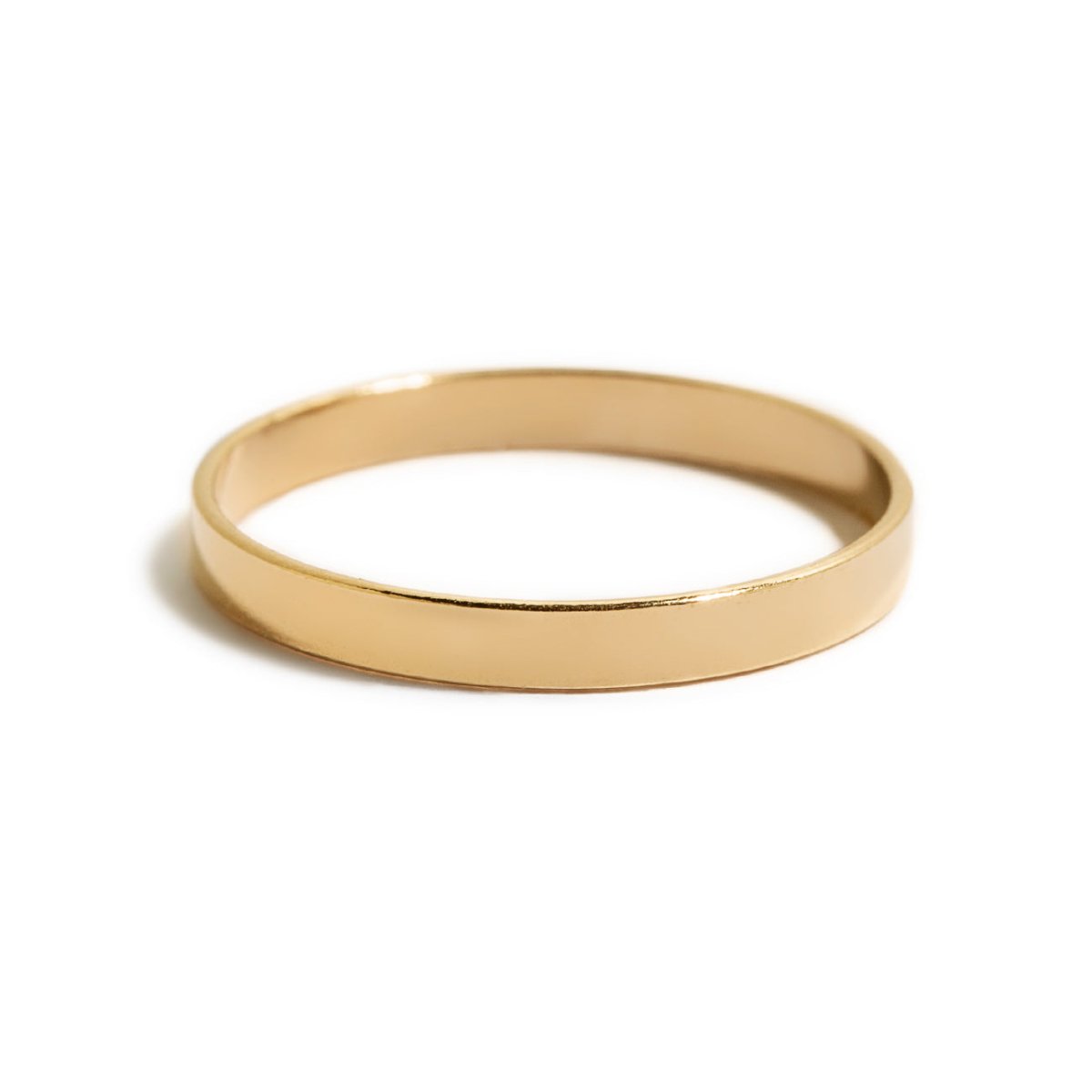 Gold-filled flat band ring, a slim plain band, on a white background