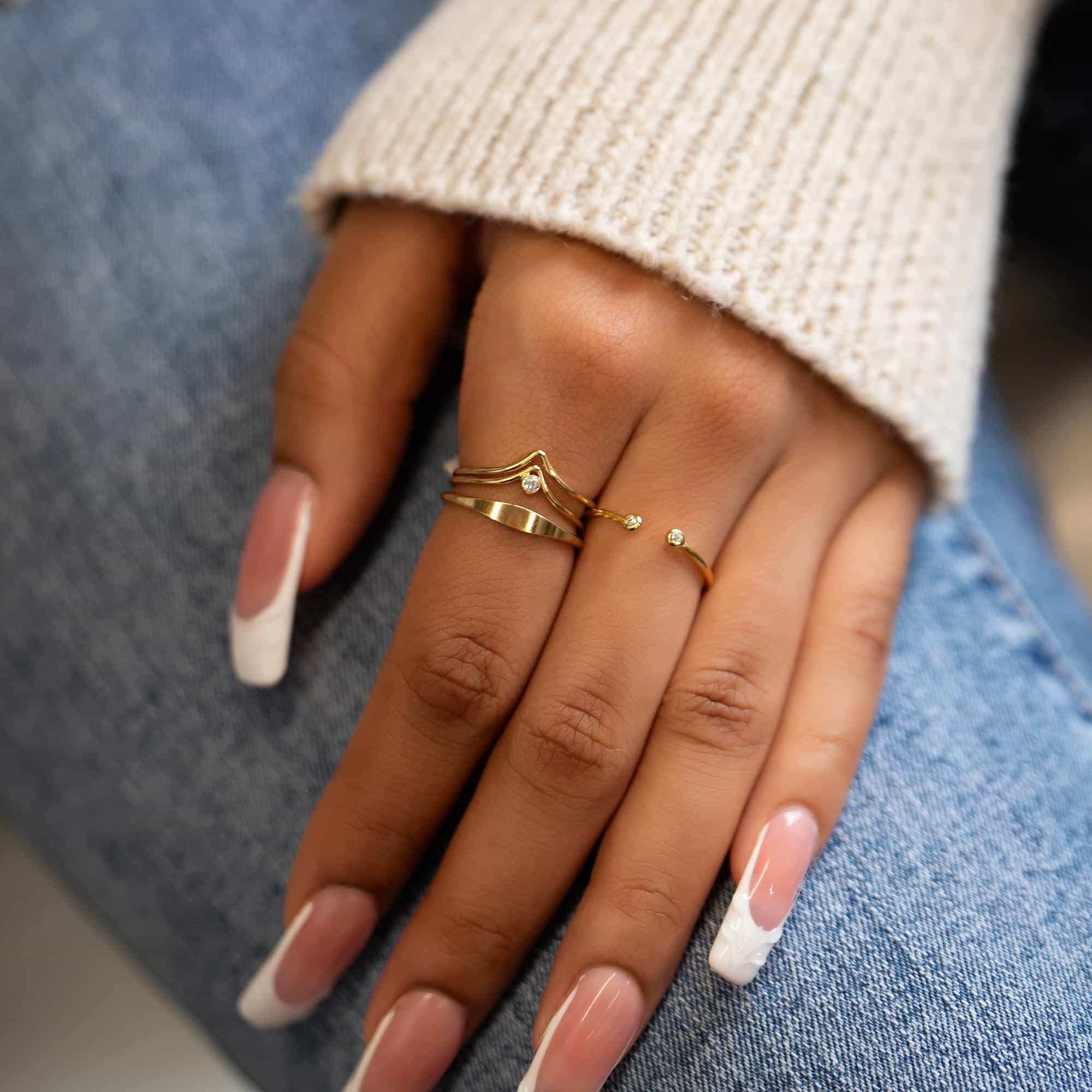 Gold vermeil open ring with a clear-stone tip worn on a model's finger, top view