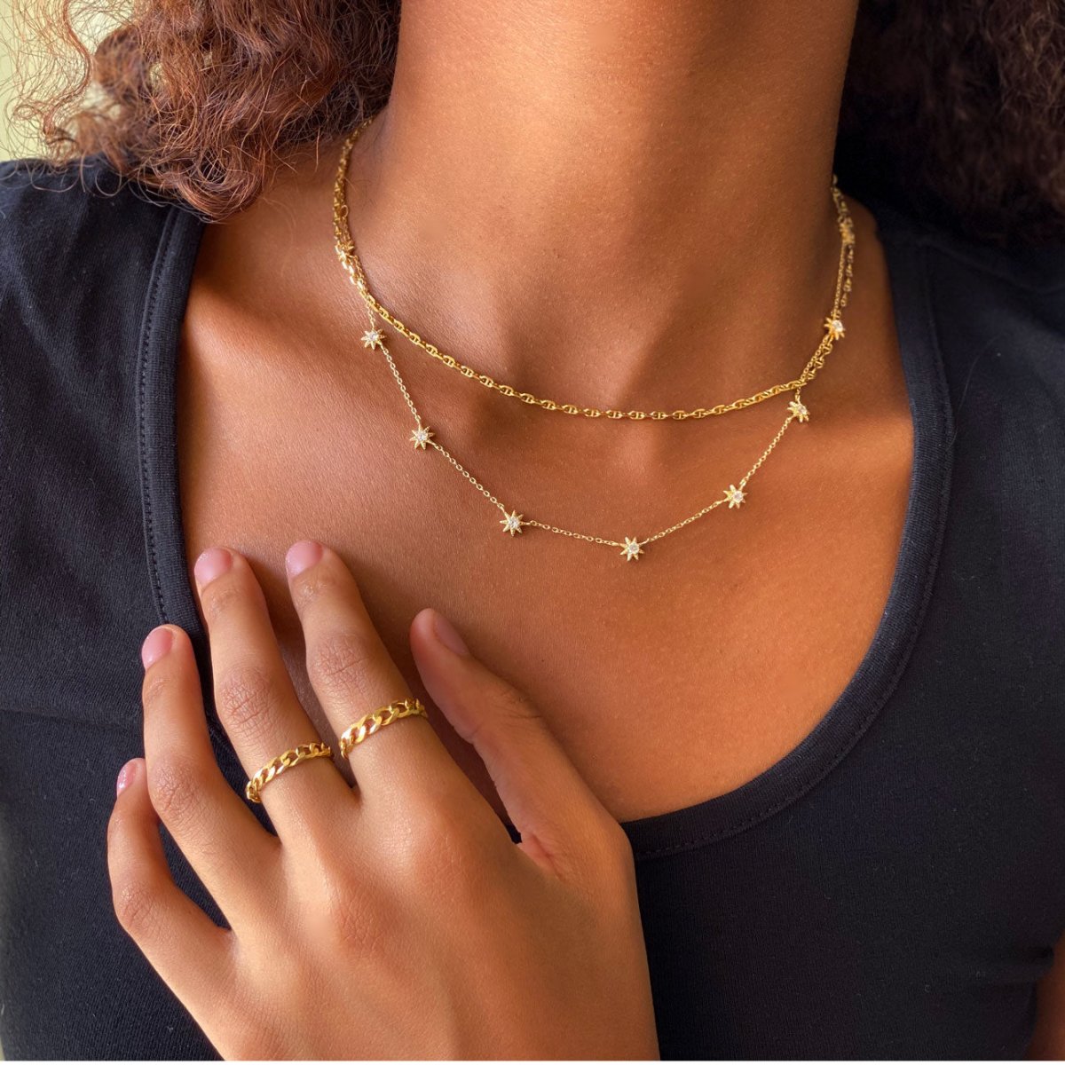 Gold vermeil Marina chain and starburst station necklaces with white zirconia, layered on a model's chest