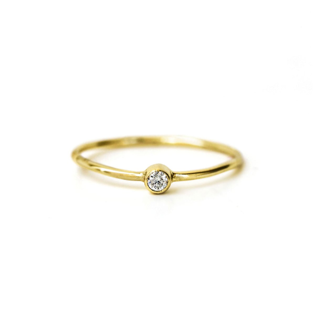 Gold-filled thin solitaire ring with a bezel-set round white zirconia, on a white background