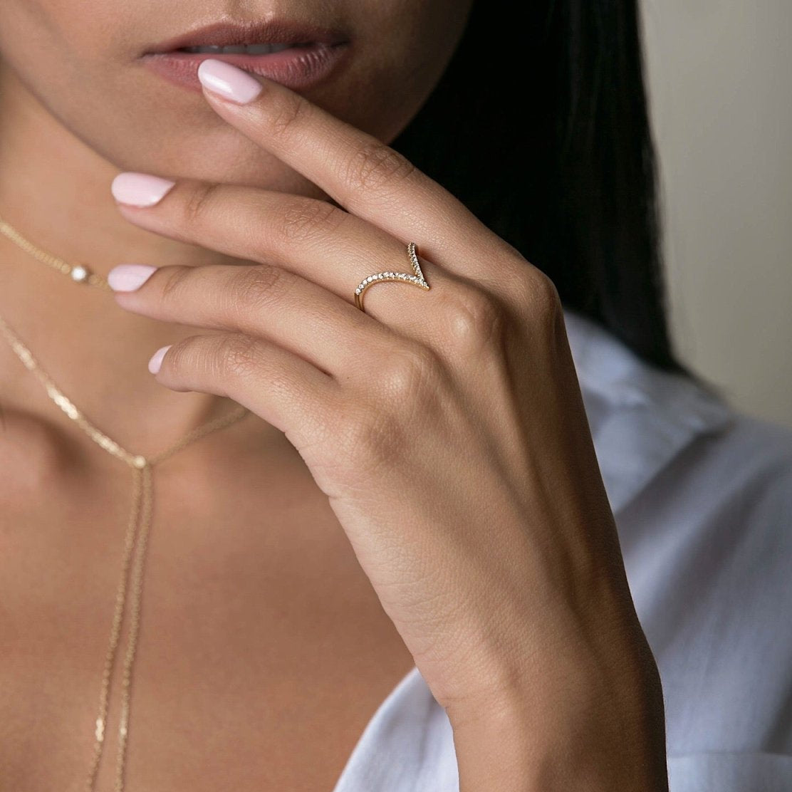 Gold vermeil pavé chevron ring with clear crystals shown on a model's finger