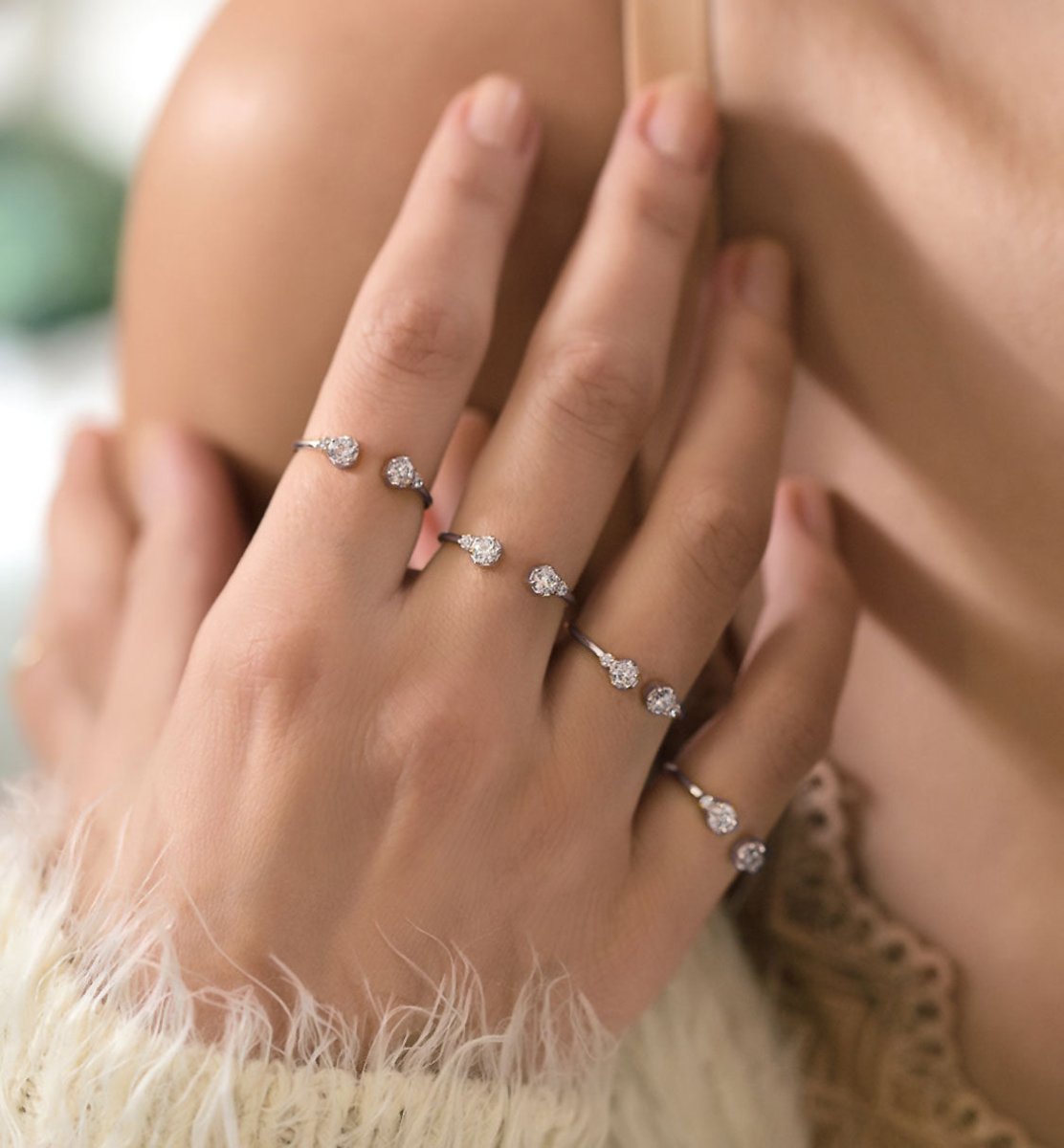 Sterling silver open cuff ring with clear zirconia stones, styled in a ring stack on a hand