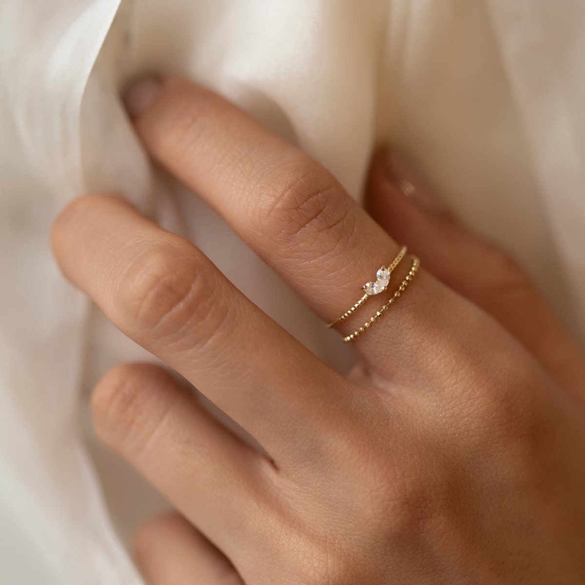 Gold vermeil twin pear white zirconia ring shown on a model's finger, close-up detail