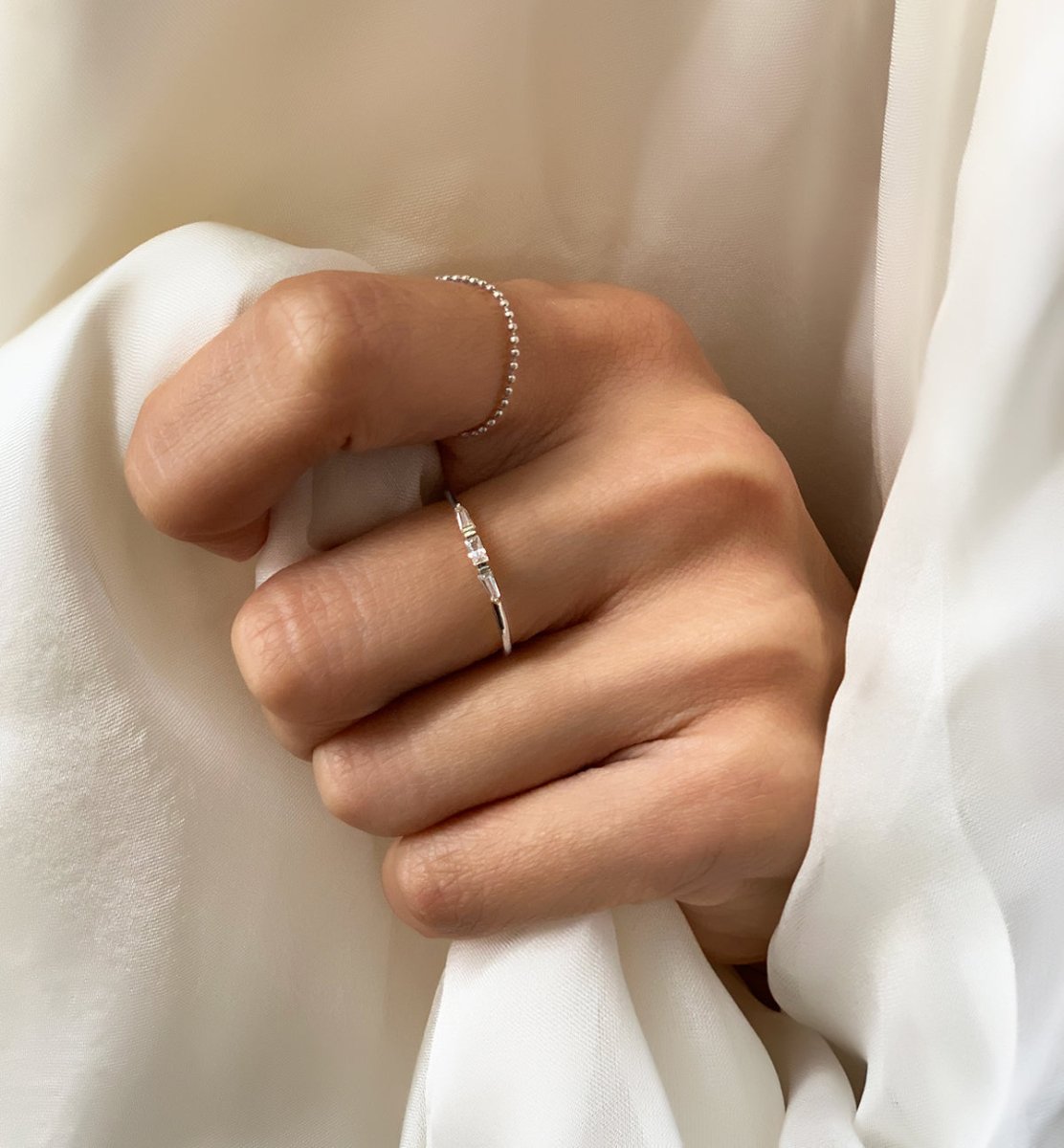Sterling silver baguette ring with a clear stone, shown on a model's finger