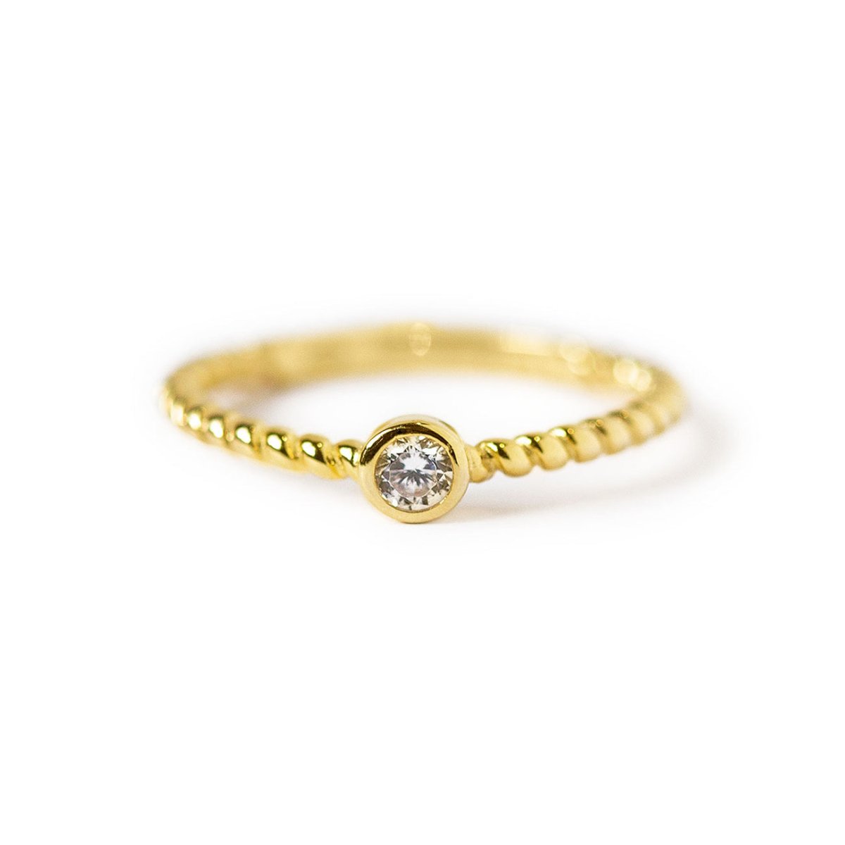 Gold vermeil solitaire rope ring with a round clear stone, on a white background
