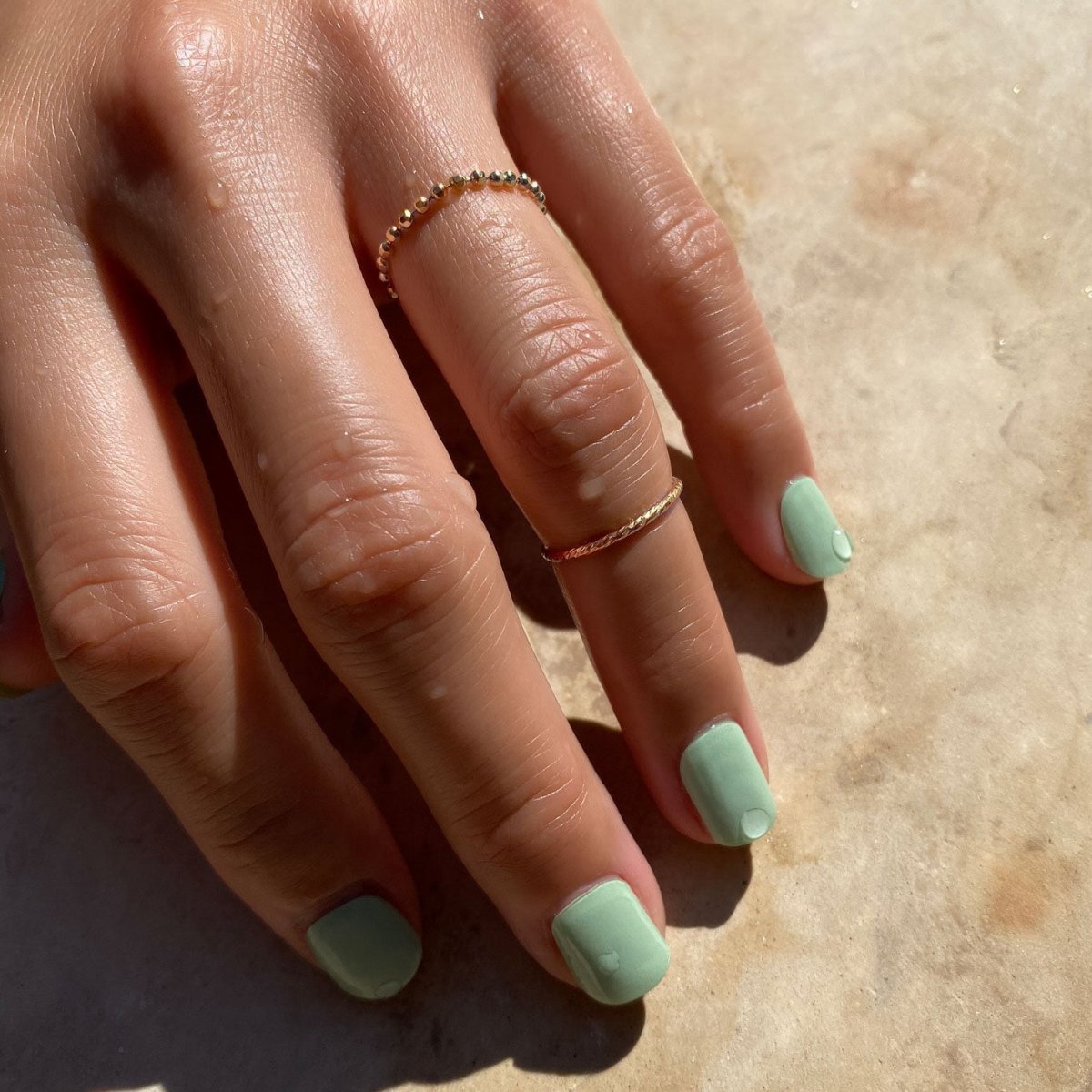 14K gold beaded Shimmer ring stacked with a thin band, shown on a model's finger