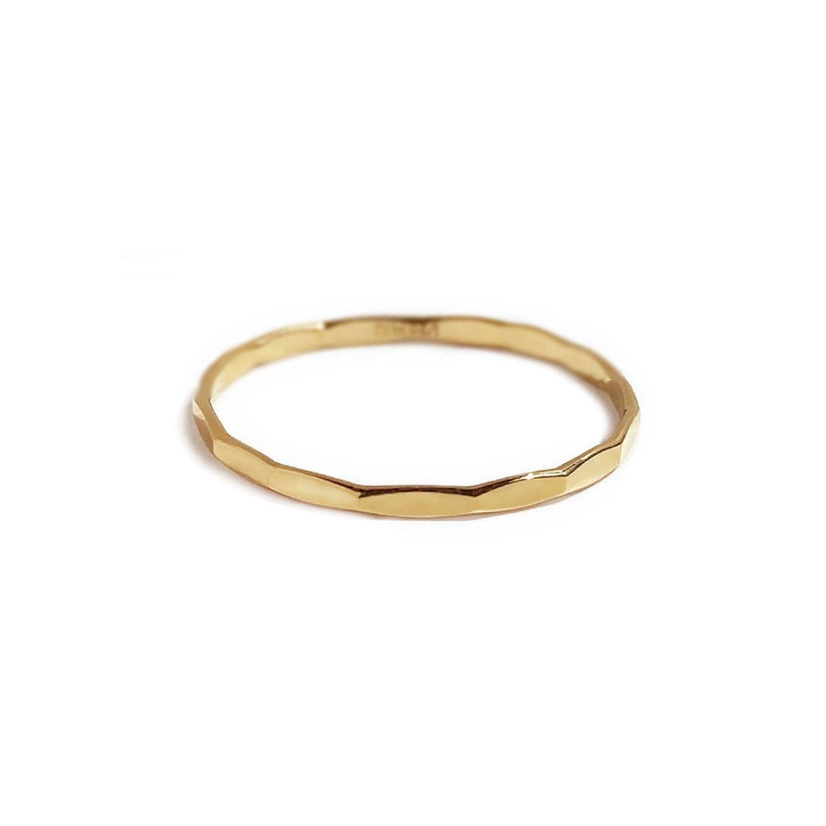 14K gold hammered thin stacking ring with a faceted band, on a white background