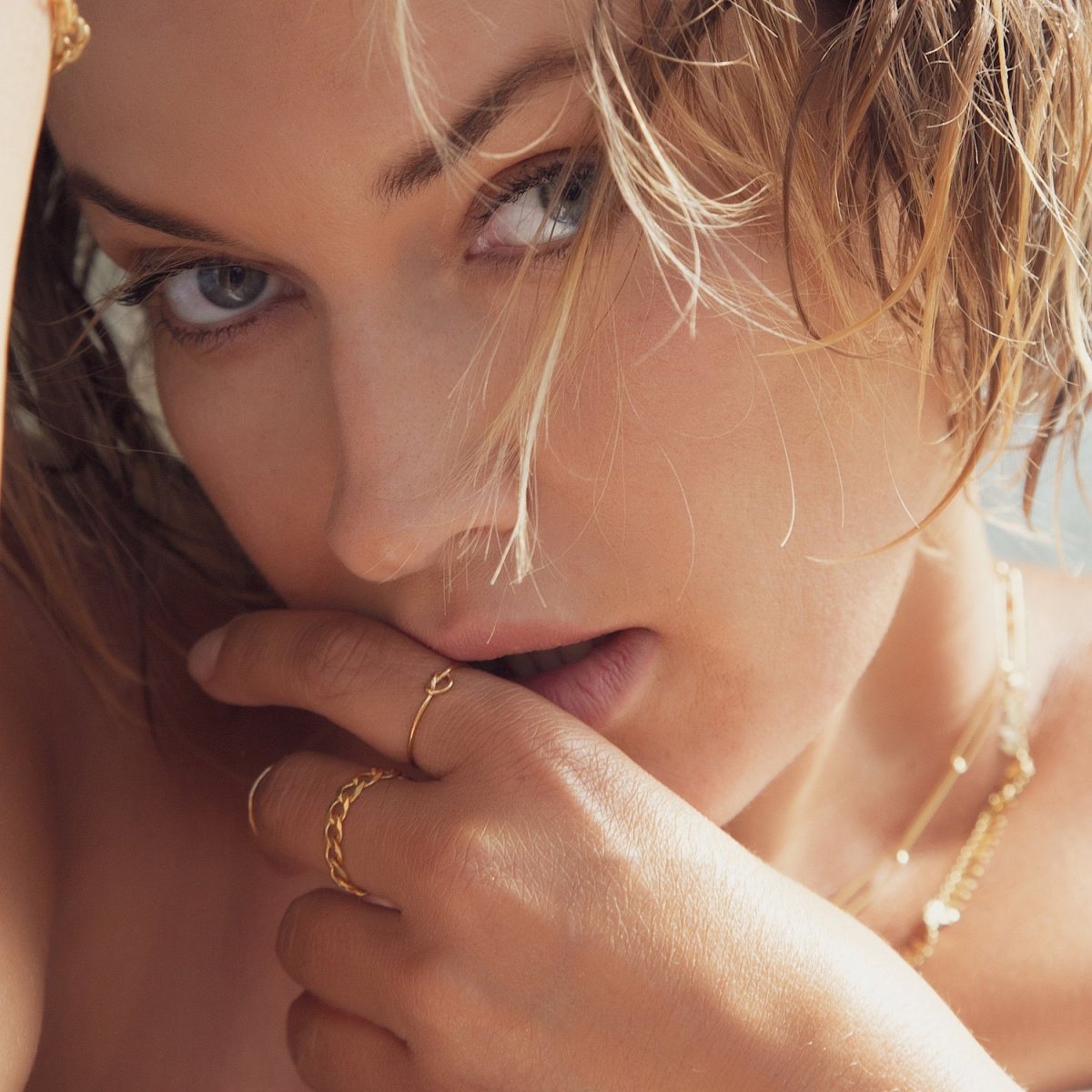 Gold-filled knot ring and a thin chain ring shown stacked on a model's fingers