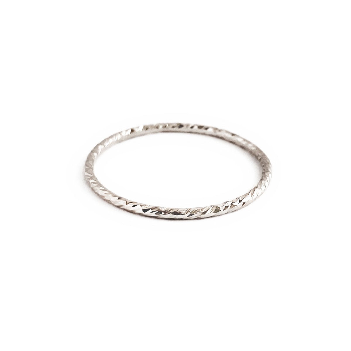 Sterling silver thin band ring with a sparkly diamond-cut texture, on a white background