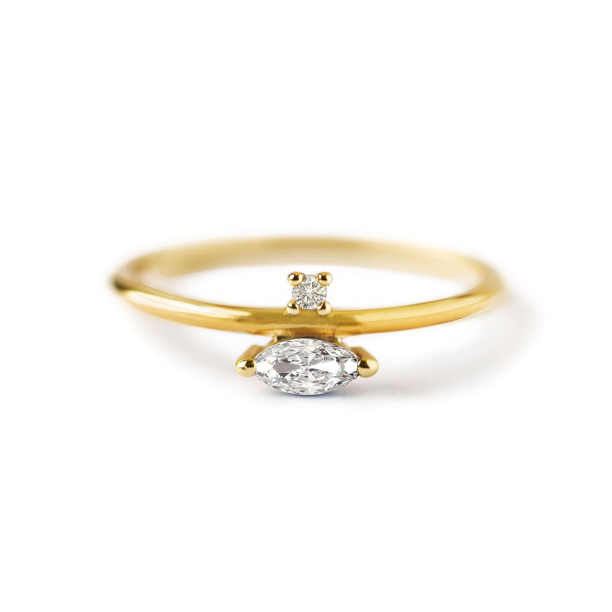 Gold vermeil marquise band ring with a horizontal clear stone and a small round accent, on a white background