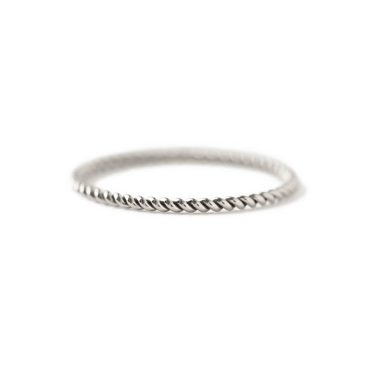 Sterling silver thin twisted rope ring on a white background, close-up detail