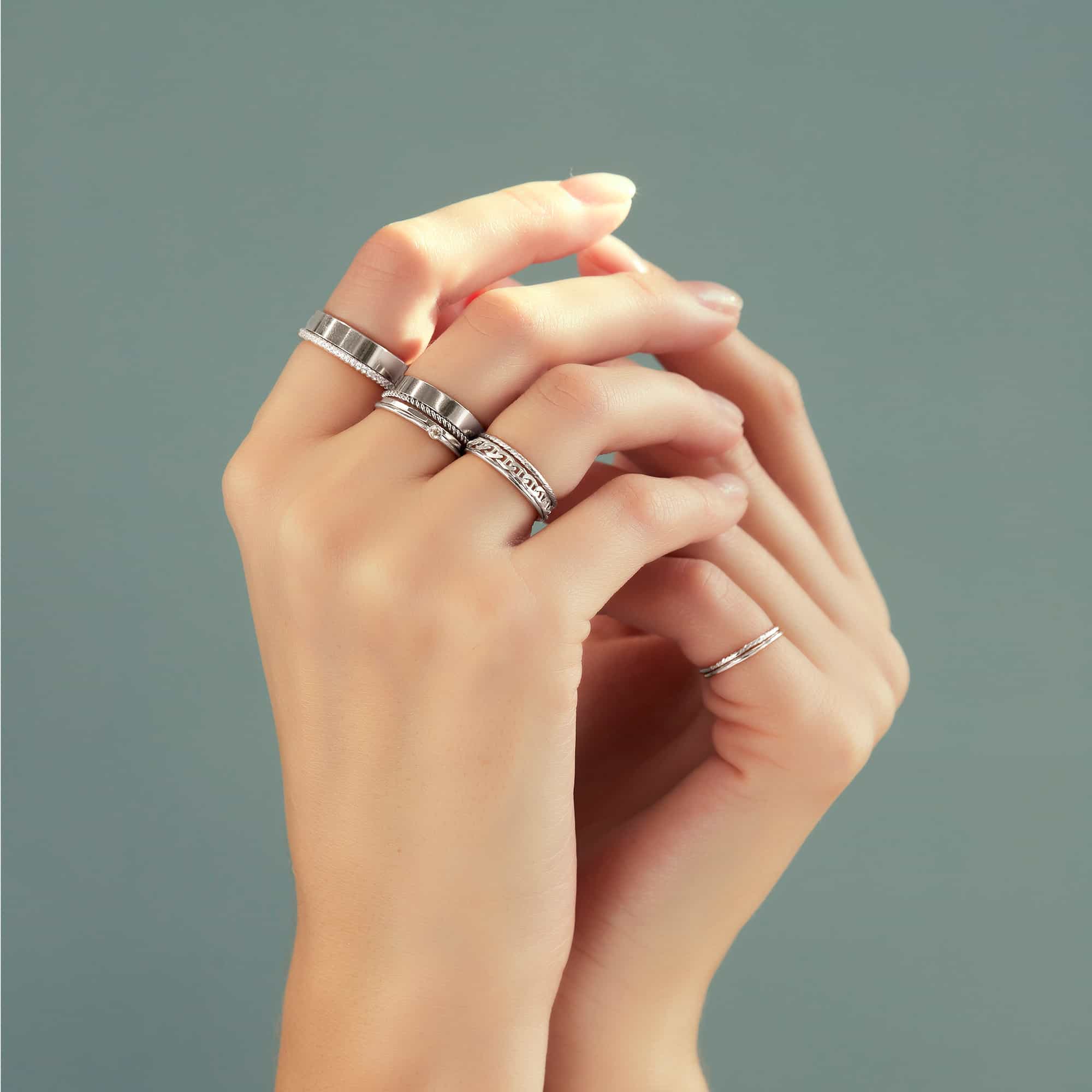 Sterling silver pavé eternity ring with white zirconia, shown stacked on clasped hands