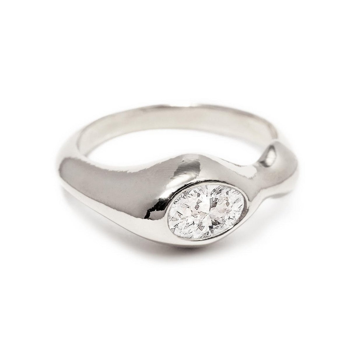 Sterling silver sculptural ring with an oval white zirconia, on a white background