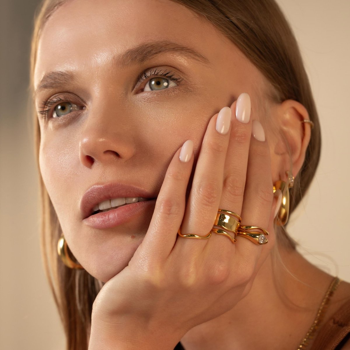 Sterling silver melted wide band statement ring stacked on a hand, shown on a model's finger