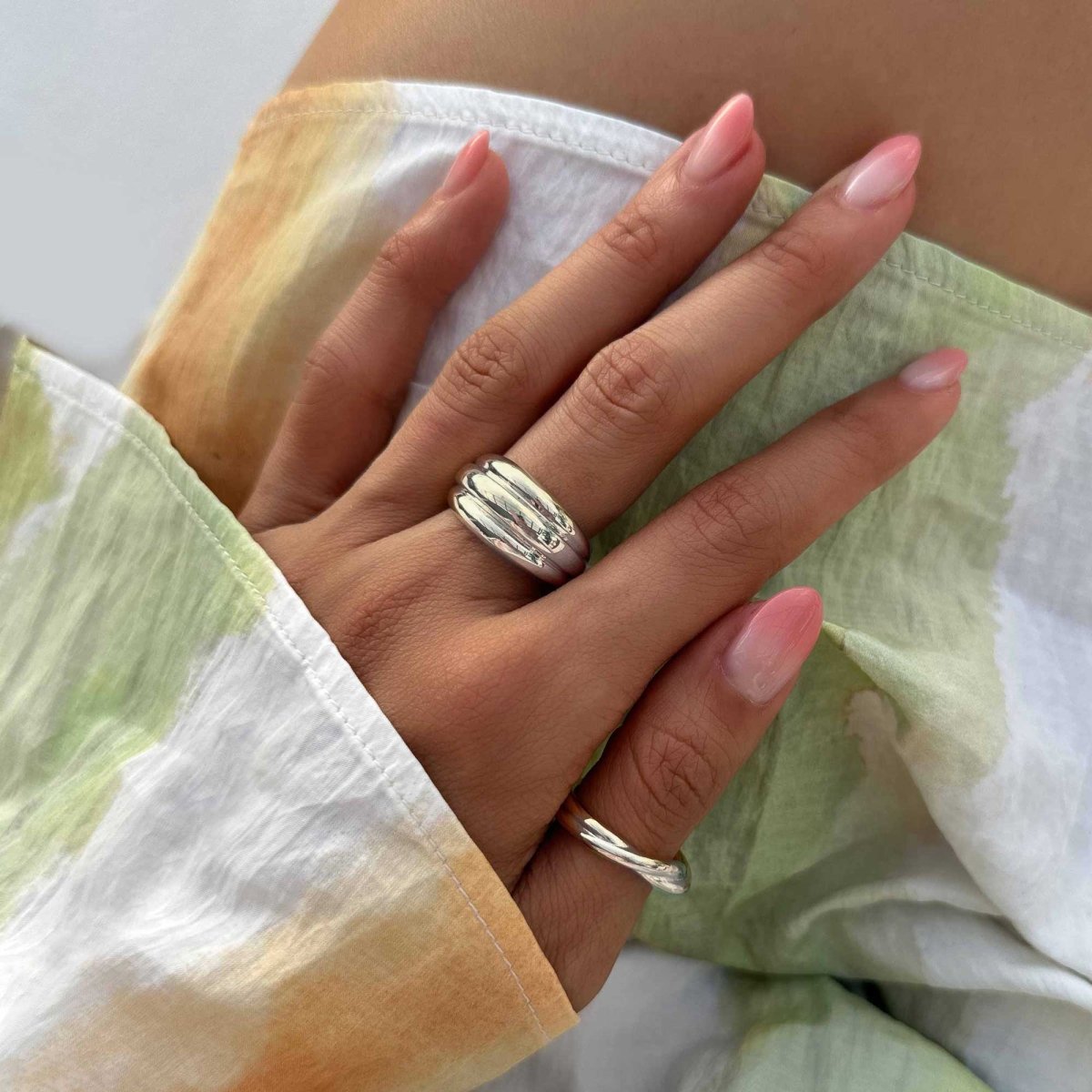 Sterling silver dome statement ring shown on a model's finger with silver studs and chain