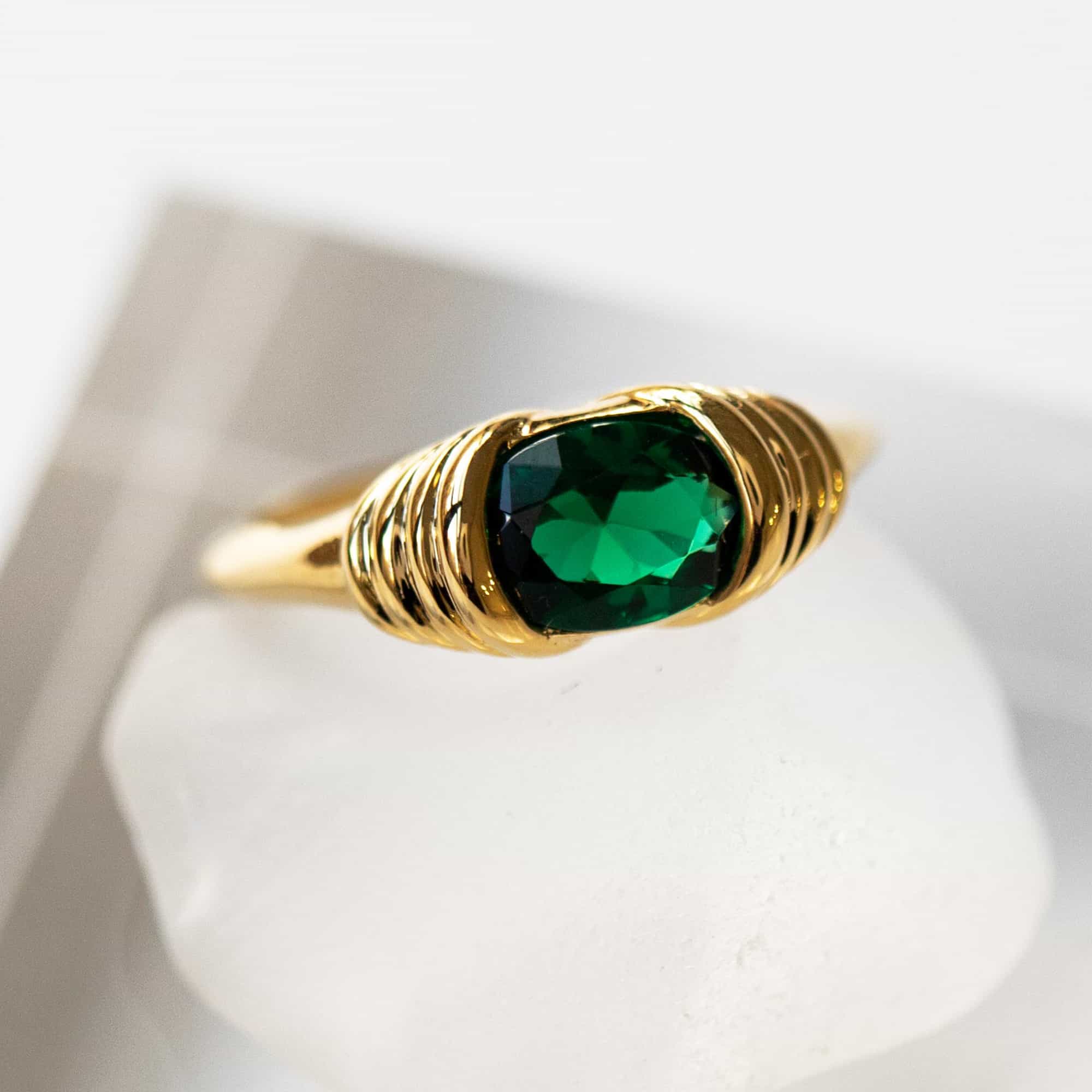Gold vermeil ring with a cushion-cut green stone and ribbed shoulders, close-up detail