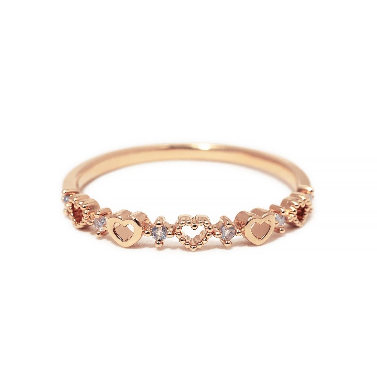 Rose gold vermeil heart band ring with open and solid hearts and clear stones, on white background