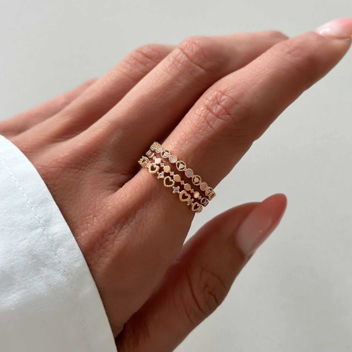 Rose gold vermeil flat beaded stacking ring shown stacked with two bands on a model's finger
