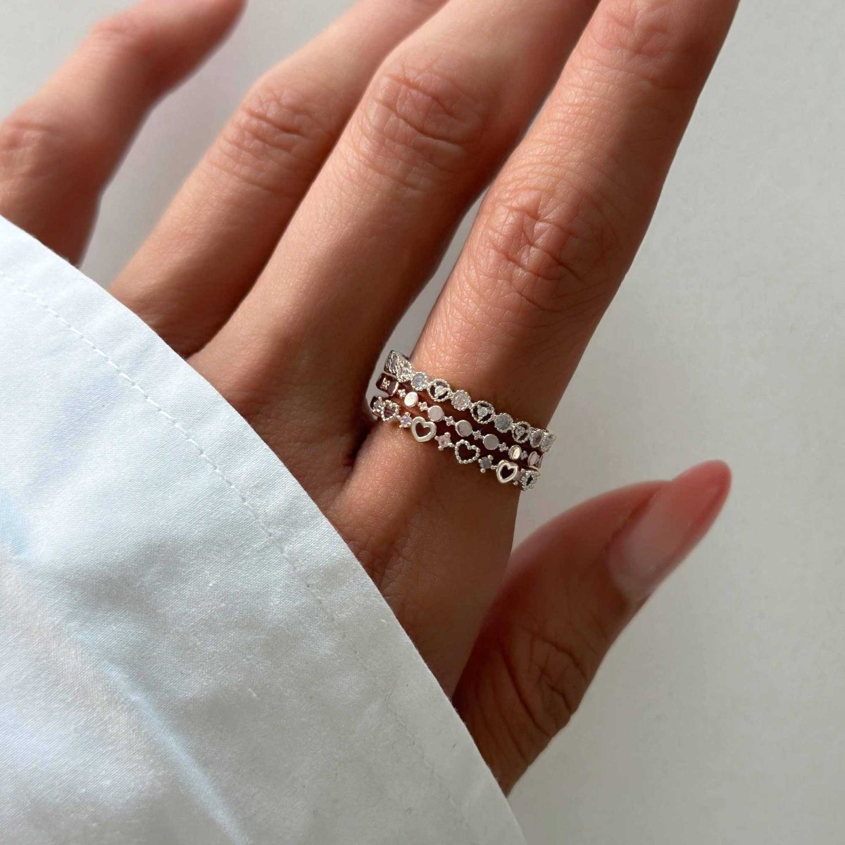 Sterling silver flat beaded stacking ring shown stacked with two bands on a model's finger