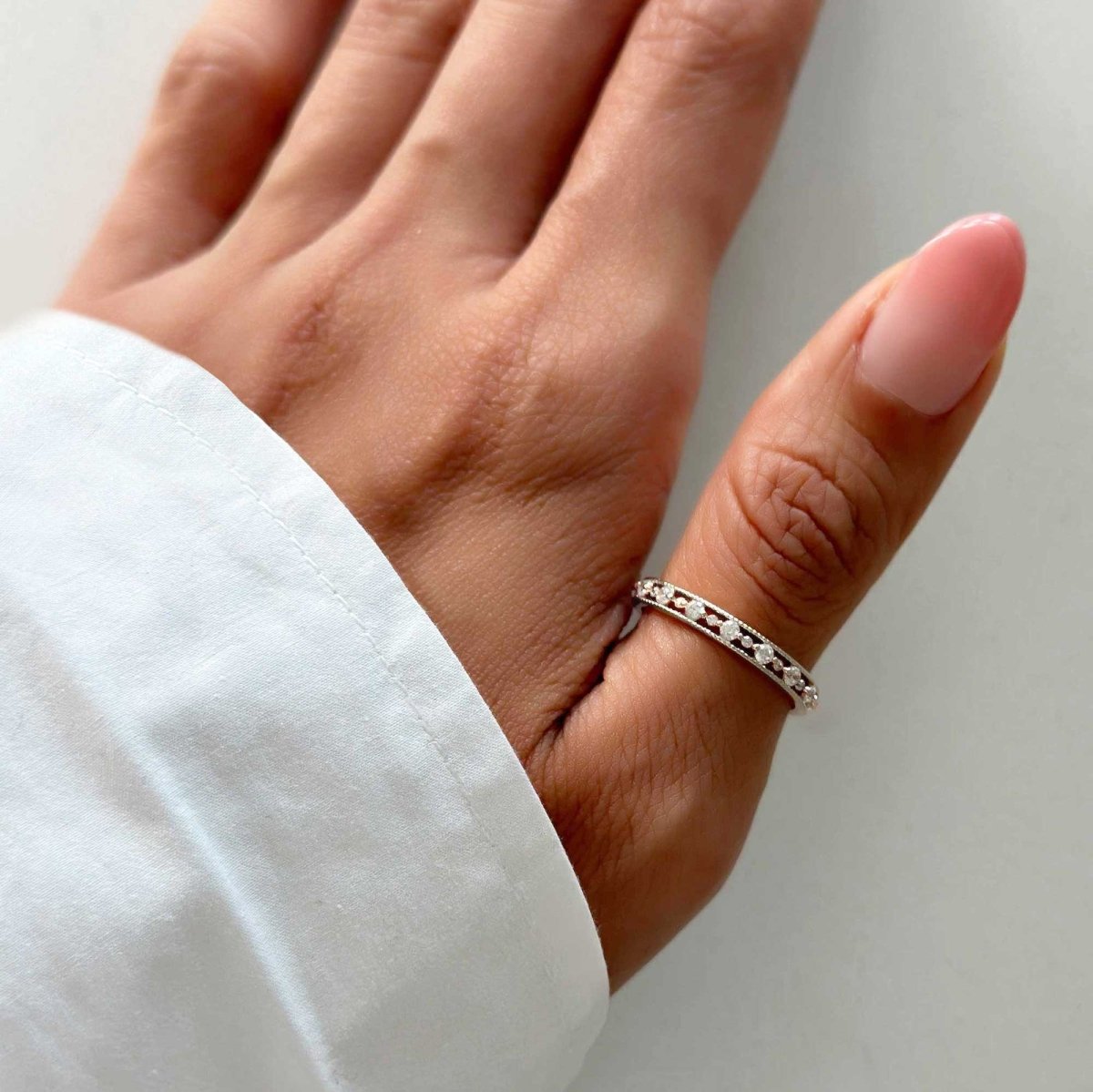 Sterling silver eternity stacking ring set with white zirconia, shown on a model's finger