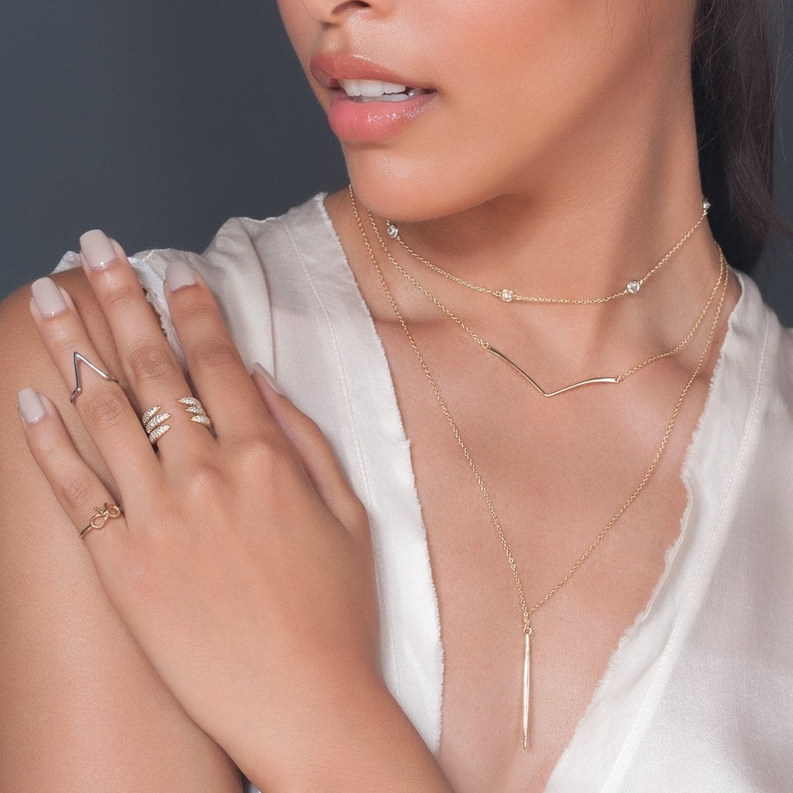 Gold vermeil chevron bar necklace shown layered on a model's neckline