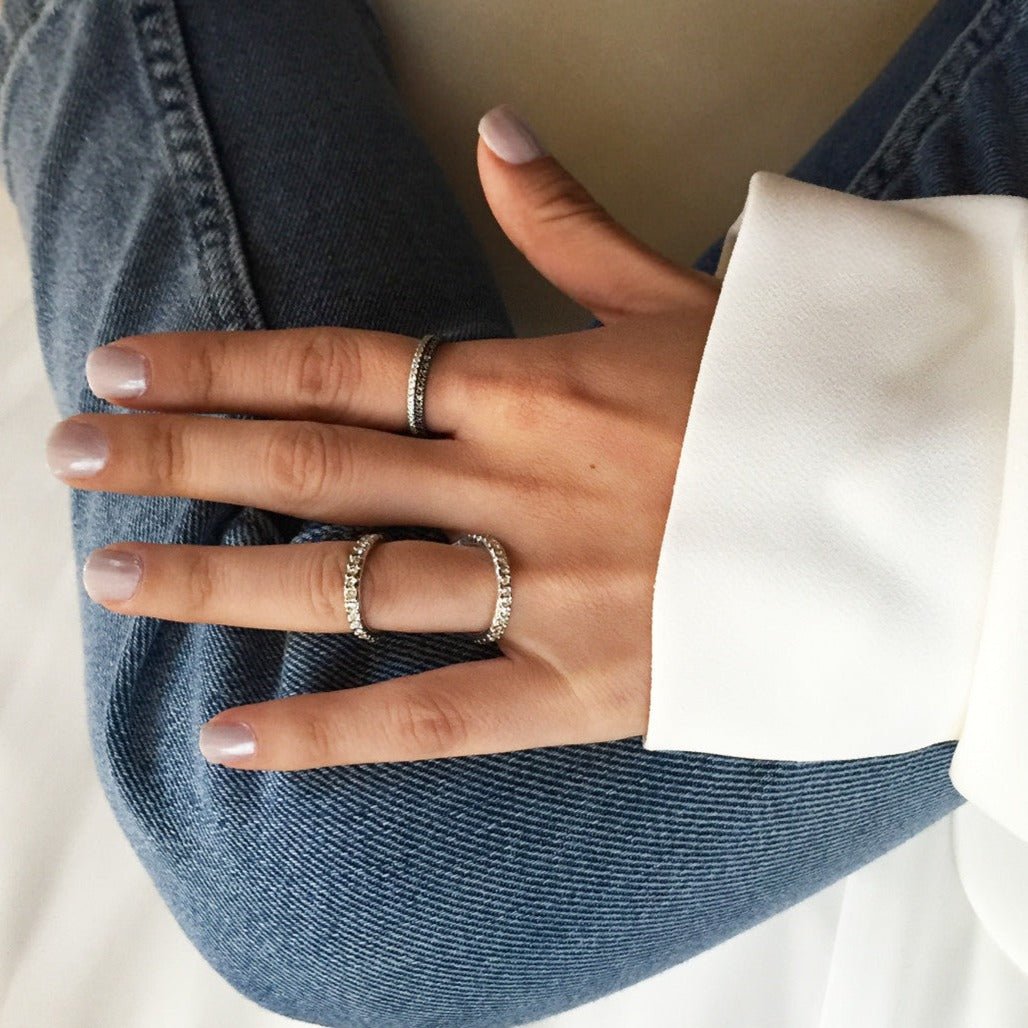 Sterling silver pavé eternity ring with white zirconia, shown on a model's hand against denim
