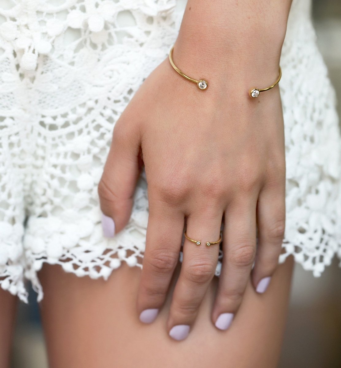 Gold vermeil open cuff bracelet with clear stones and matching open ring, shown on a model