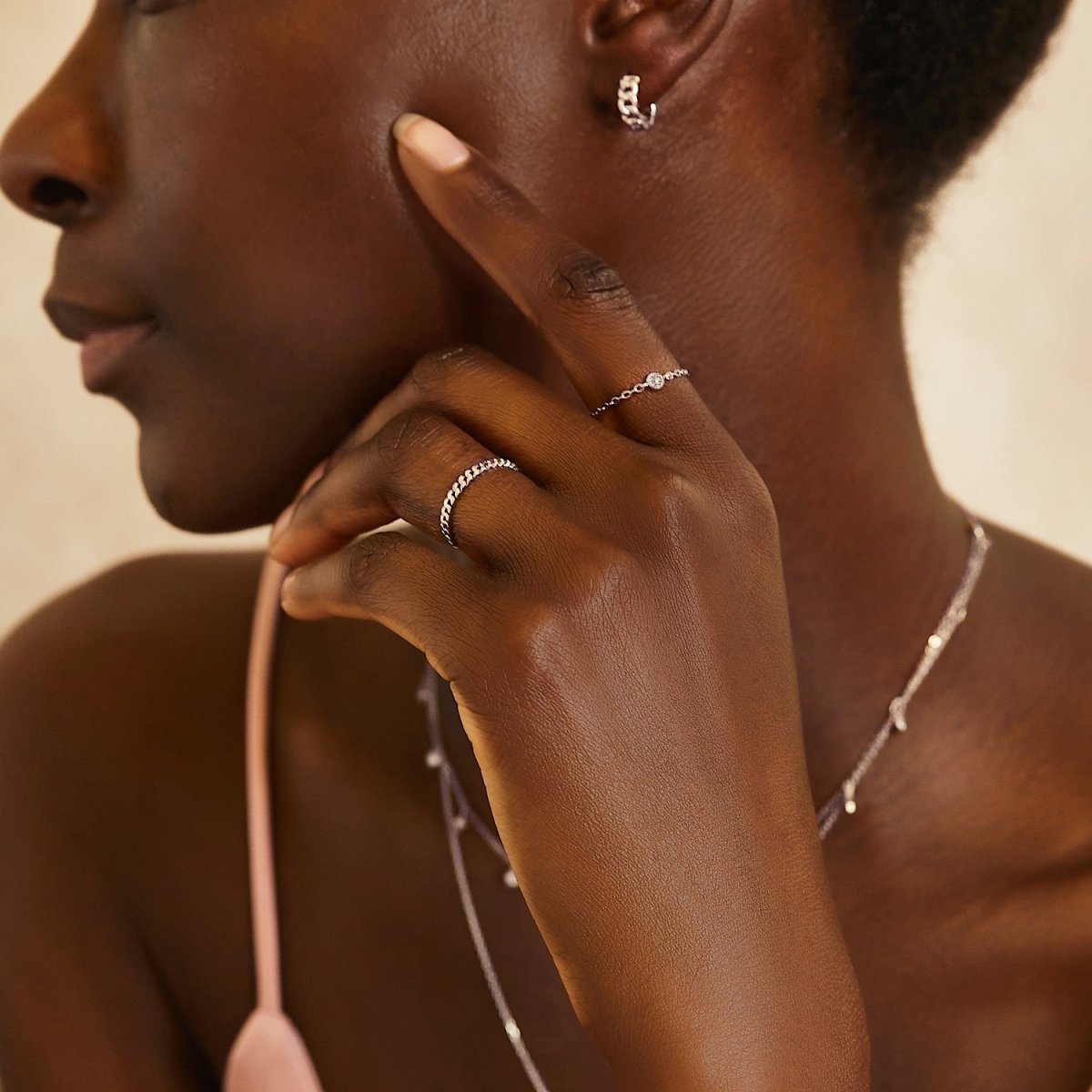 14K white gold diamond chain ring with a bezel-set diamond, shown on a model's hand with a chain necklace