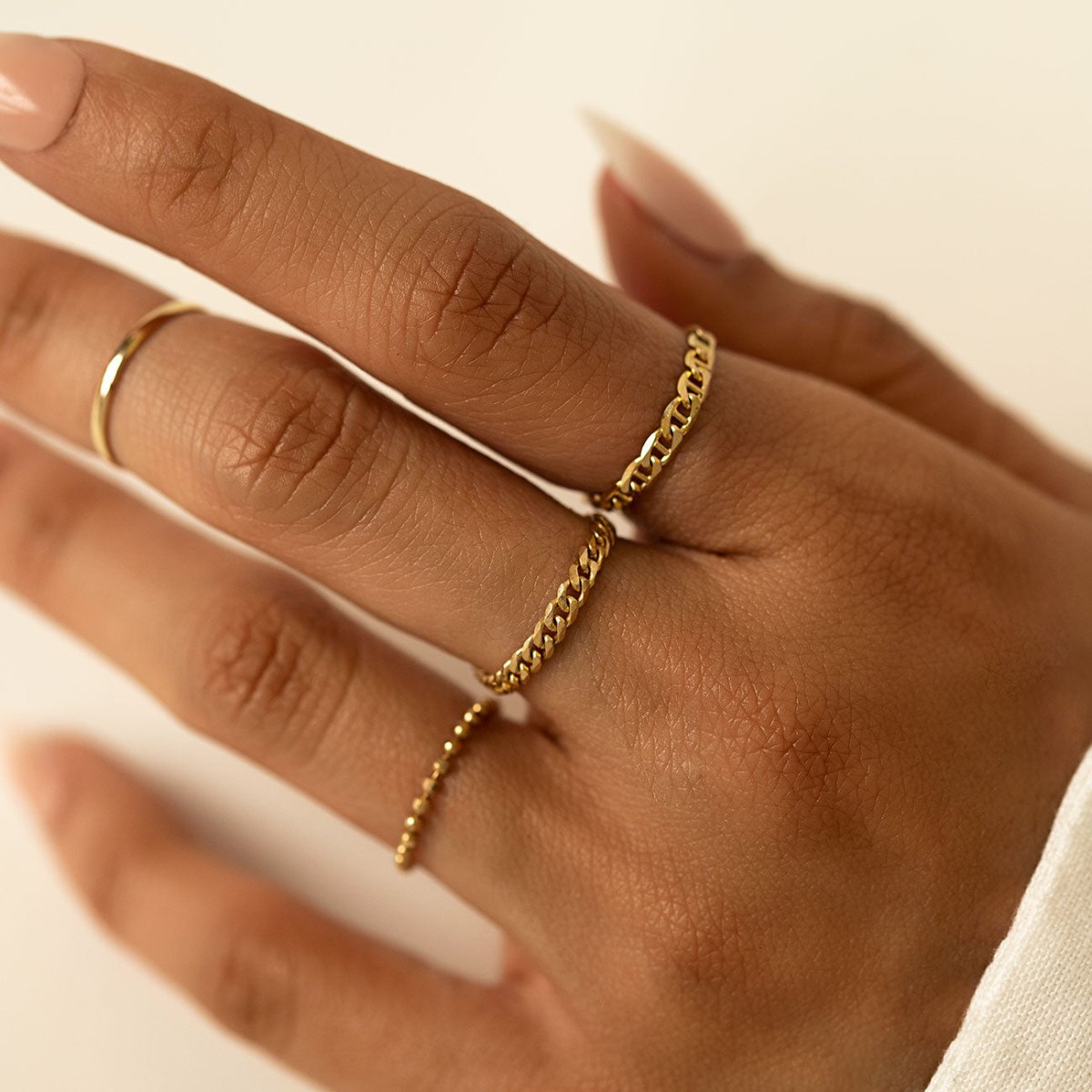14K gold bead chain ring worn with curb and beaded rings, shown on a model's hand