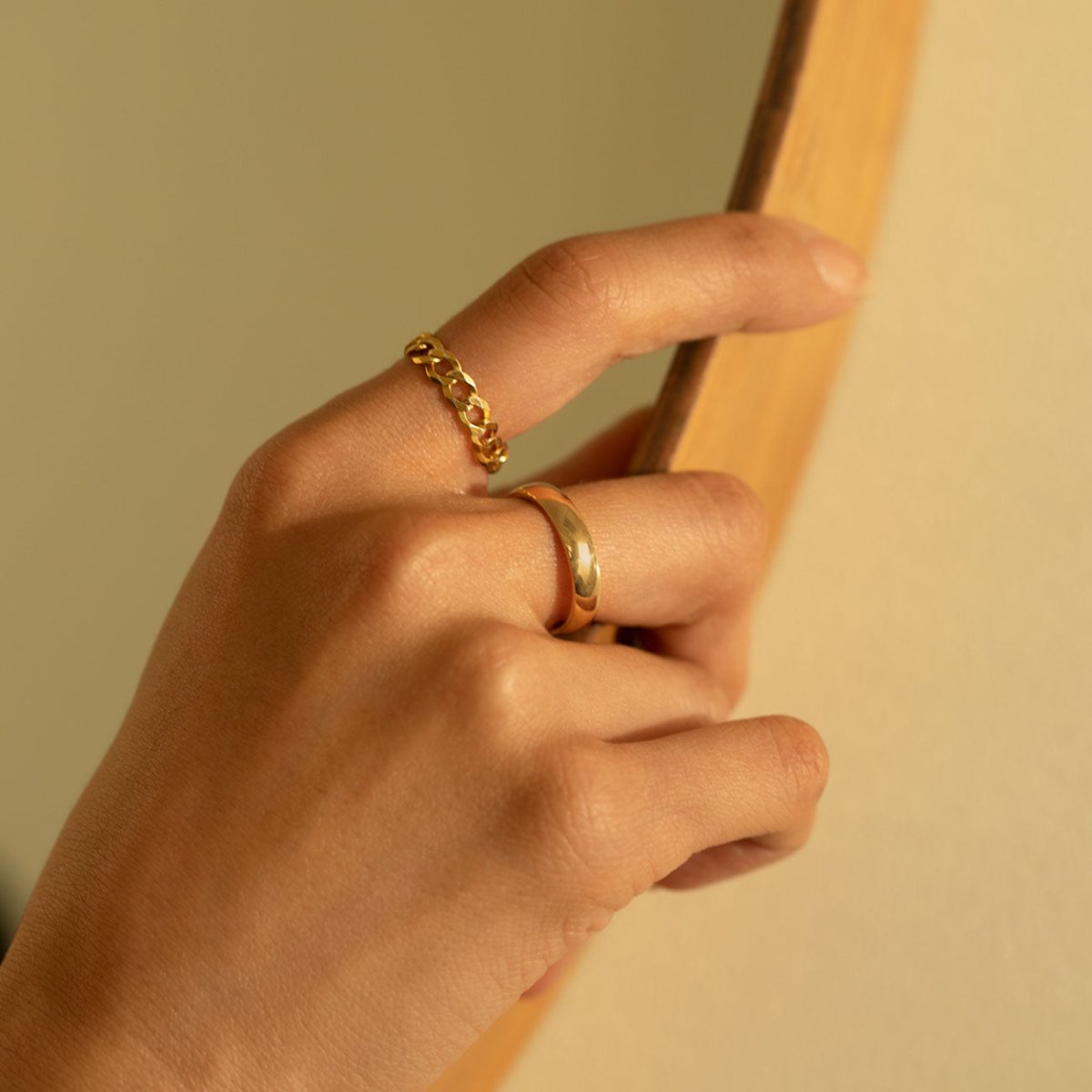 Gold vermeil thick curb chain ring shown on a model's finger above a domed band