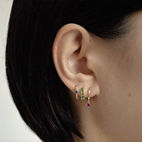 Close-up of woman's ear featuring 14K Gold Gemstone Dangle Huggies Ruby CZ Crystal and other Gemstone Huggie Earrings 