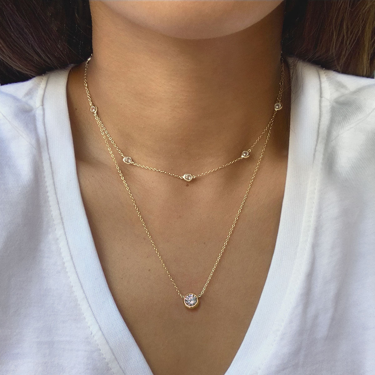 Gold vermeil layered station choker and clear solitaire pendant, shown on a model's neckline
