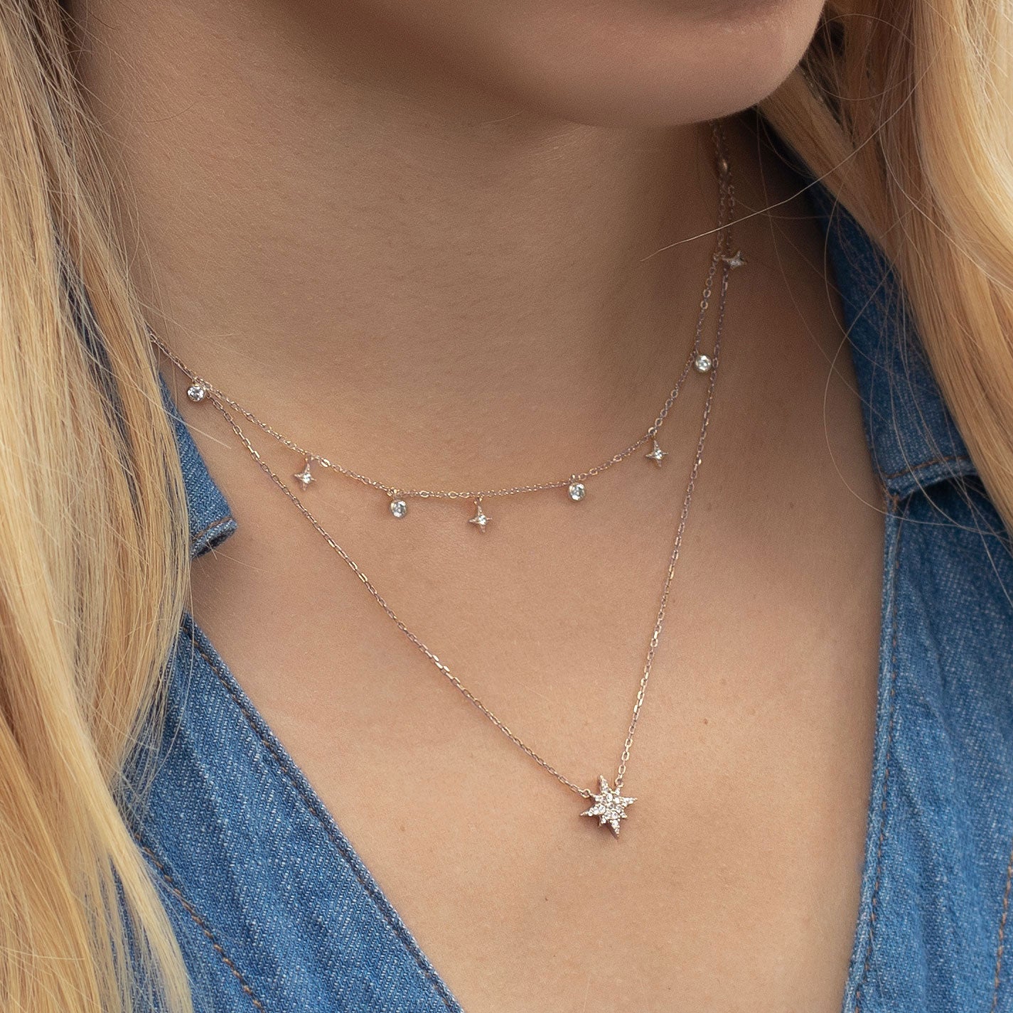 Sterling silver layered star drop and pavé star pendant chains, shown on a model's neckline