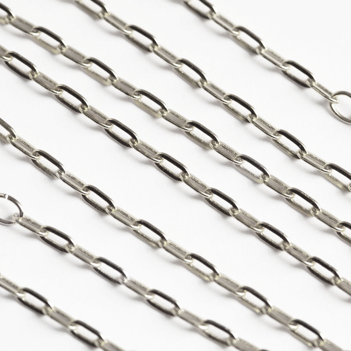 Sterling silver paperclip link chain, close-up detail on a white background