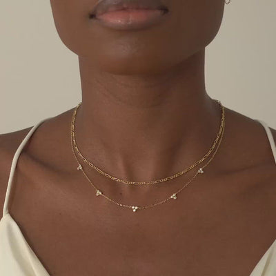 Model wearing a layered look with AMYO's Figaro Necklace and Clover Crystal Necklace in Gold Vermeil
