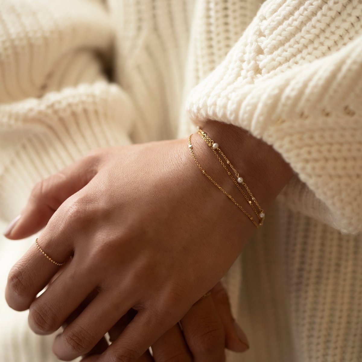 Rose gold vermeil layered chain bracelet with small pearls, shown on a model's wrist