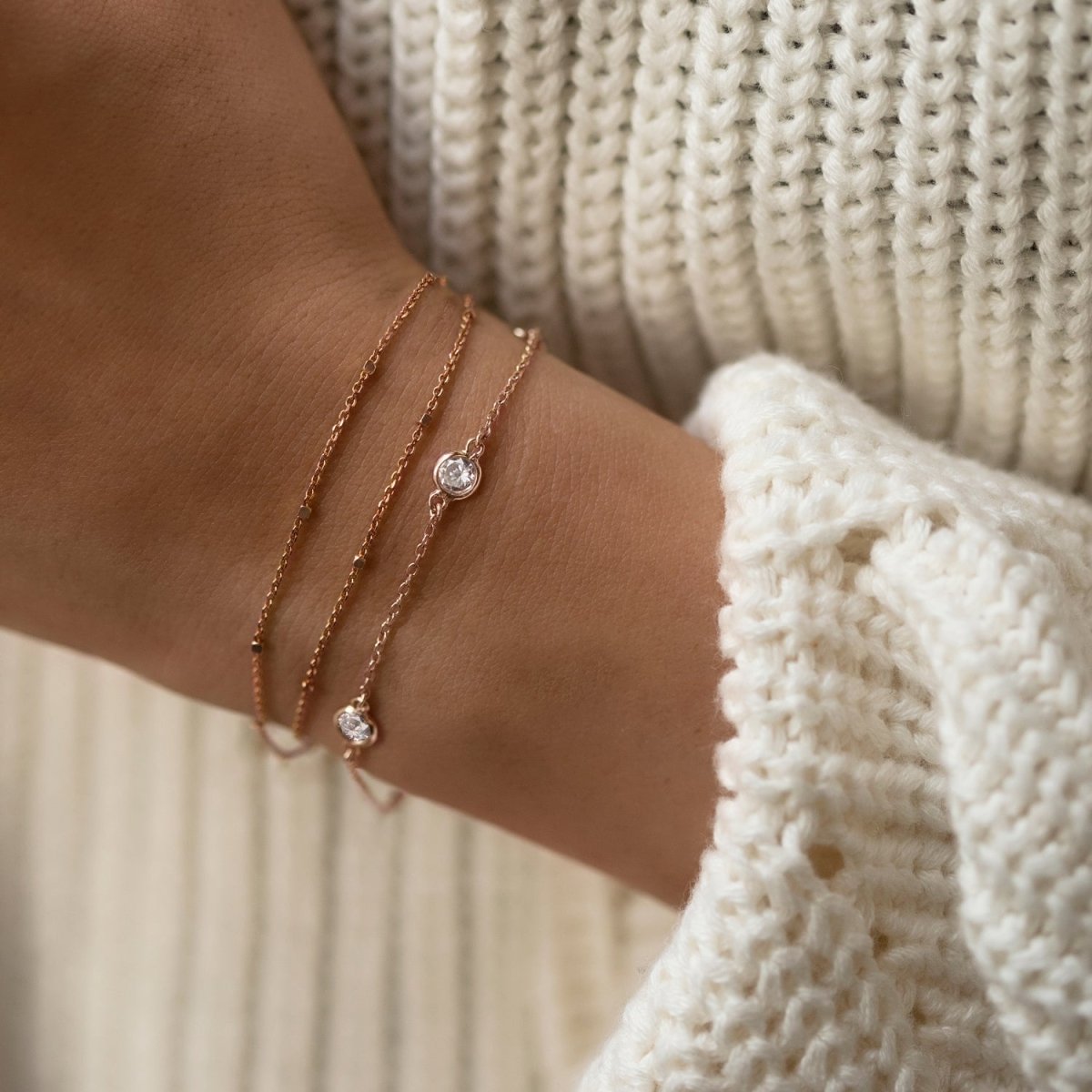 Rose gold vermeil layered chain bracelet with bezel-set clear stones, shown on a model's wrist