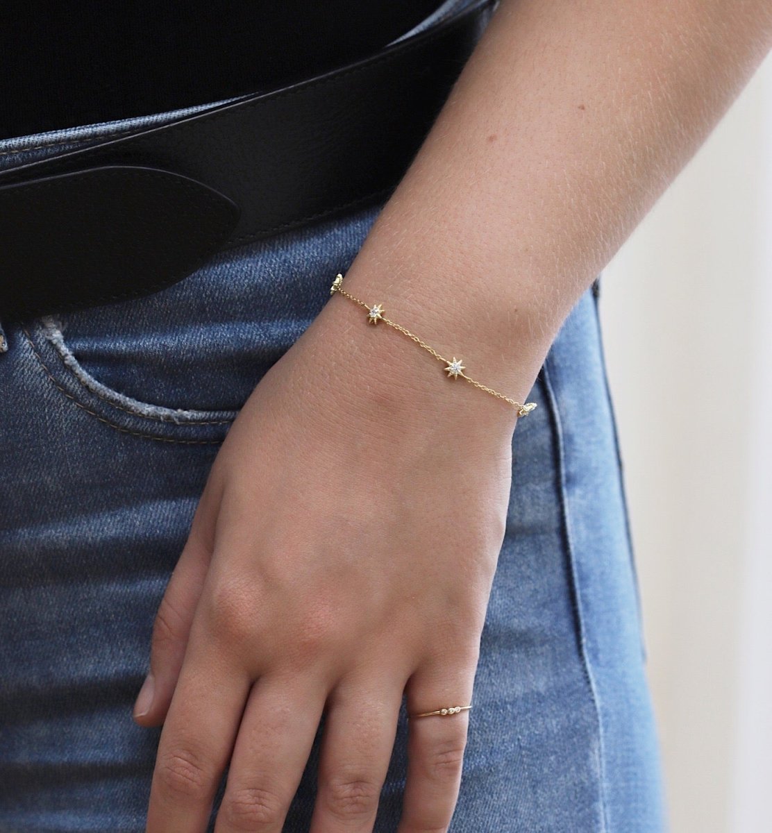 Gold vermeil pavé star station chain bracelet, shown on a model's wrist with denim