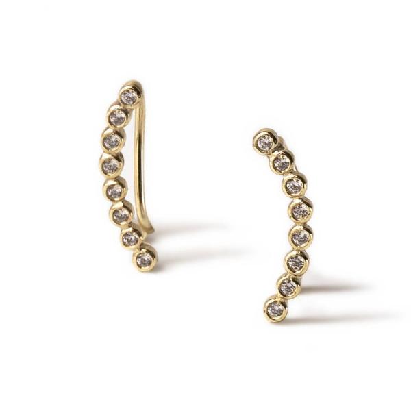 Pair of gold ear climbers lined with round white zirconia stones, on a white background