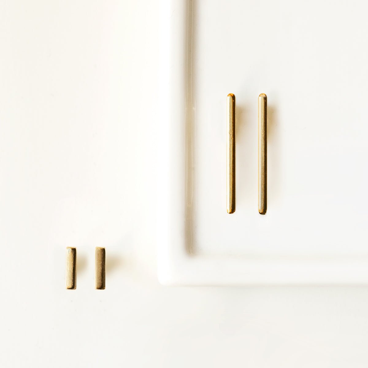Gold vermeil bar ear climbers in two lengths shown on white marble, size comparison
